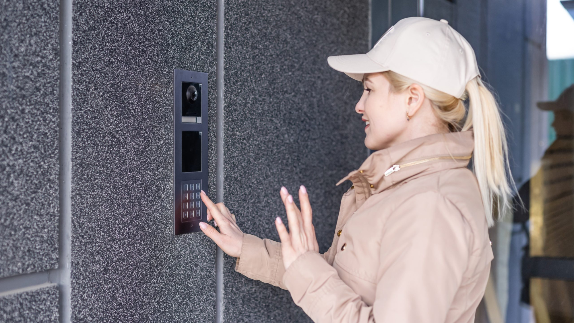 Close up the female hand presses the doorphone button. The girl is calling the intercom. Means of communication or notification of arrival and security of the entrance inside.